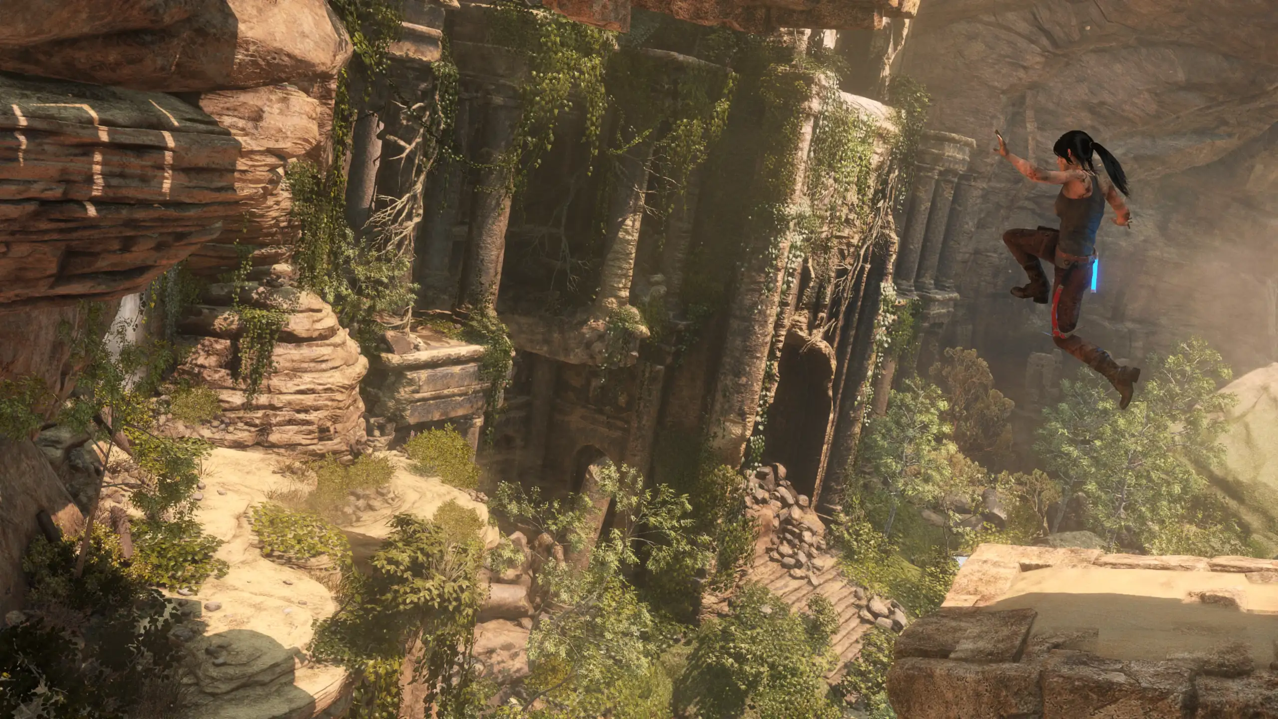 Lara Croft explorando los desfiladeros y templos excavados en la roca del desierto de Siria en Rise of the Tomb Raider