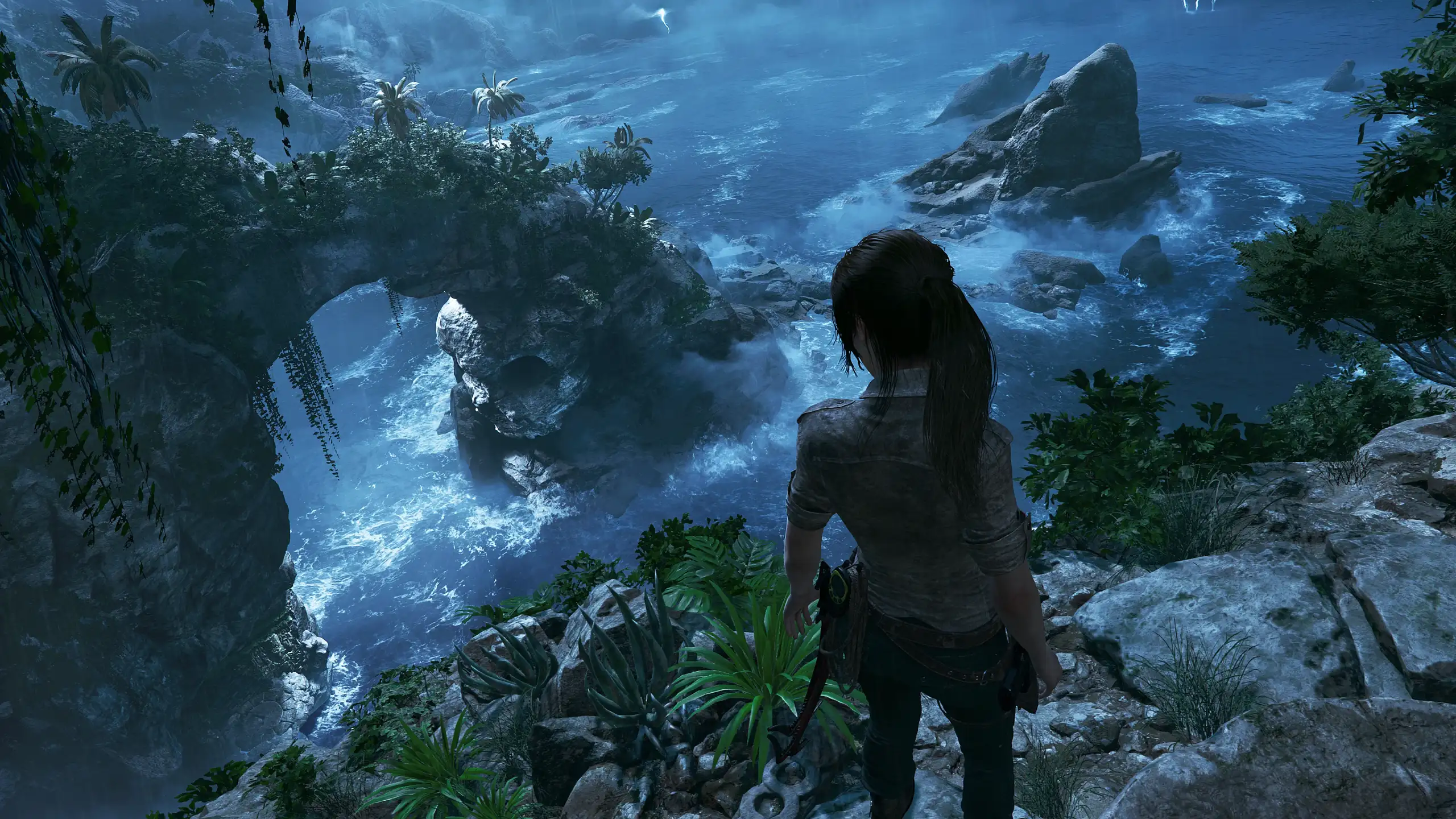 Lara Croft camuflada con lodo en la vegetación de la jungla acechando a los mercenarios de La Trinidad en Shadow of the Tomb Raider